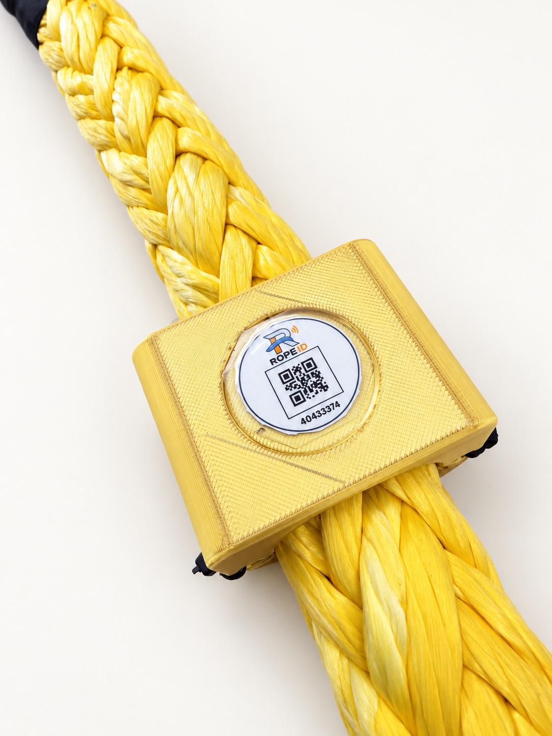 Close product view of a gold RopeID® tag mounted on a yellow synthetic rope